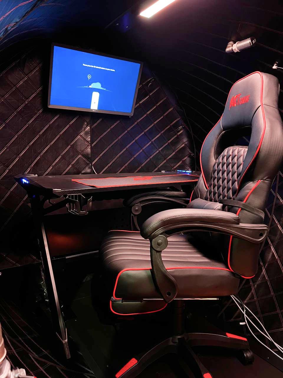 Gaming-rum med gamer-stol og skærm inde i trykkammer